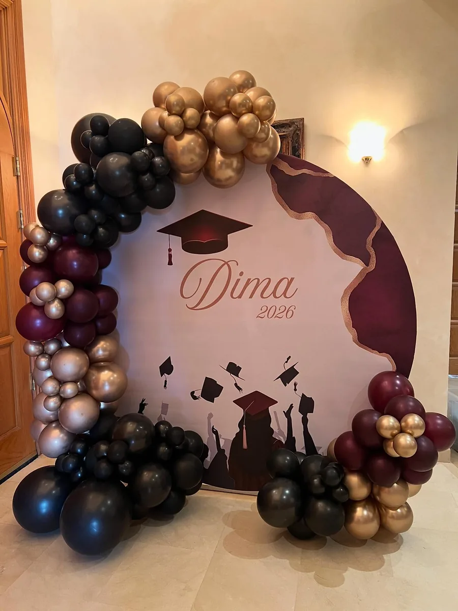 Burgundy, black and gold graduation backdrop with balloon garland
