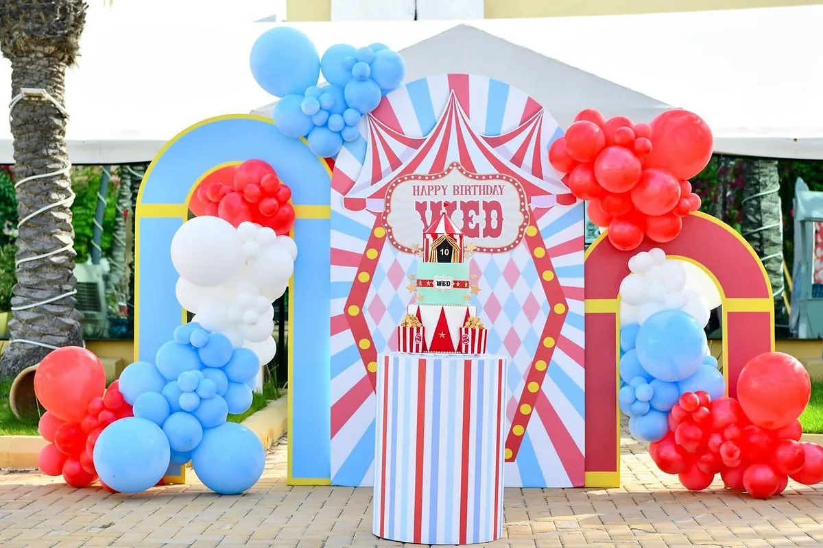Circus entrance framed with red, blue and white balloon clusters