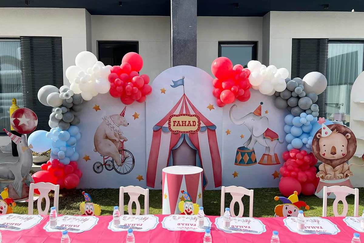 Circus birthday table arranged in front of a red, blue and white balloon backdrop