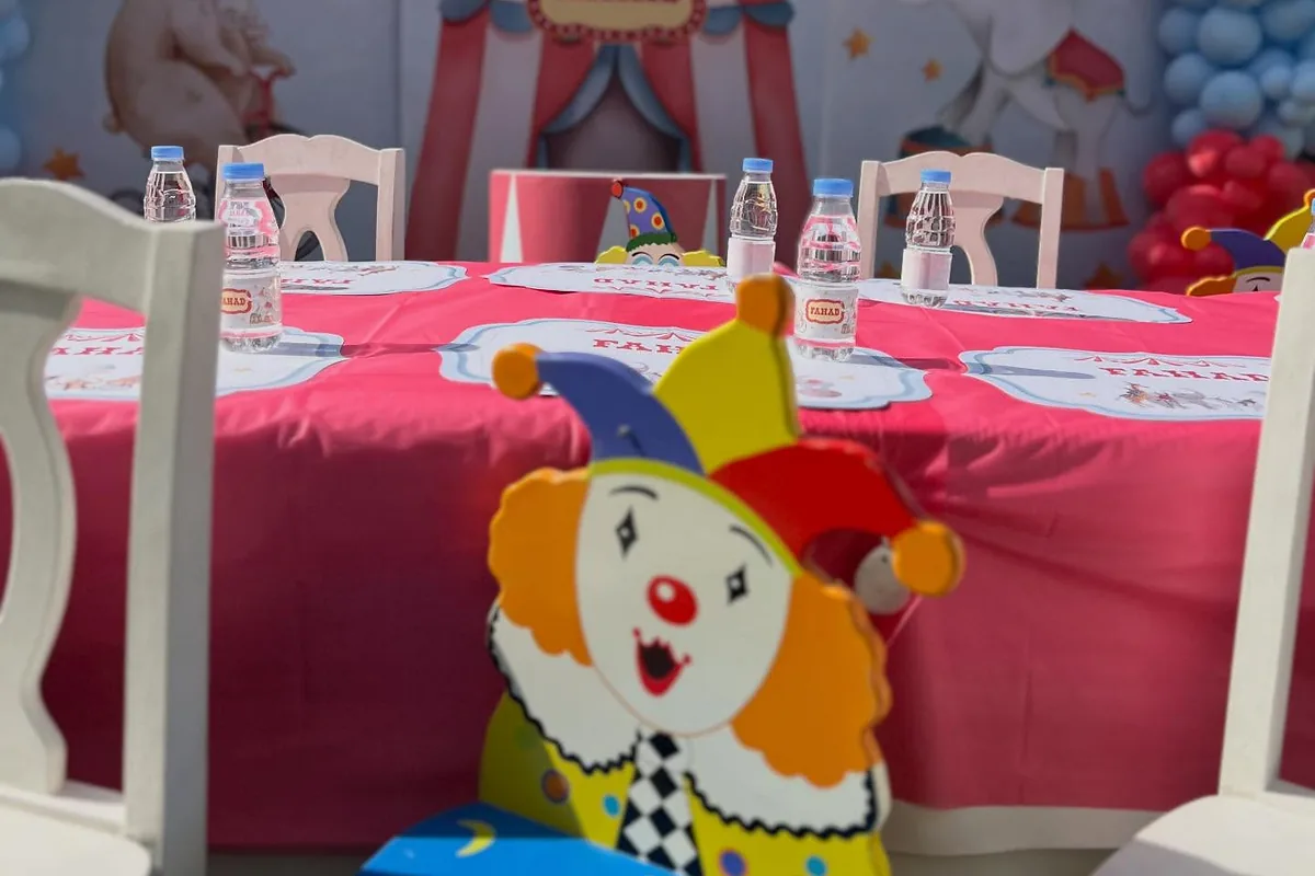 طاولة أطفال بطابع السيرك مع مهرج وخلفية بالونات