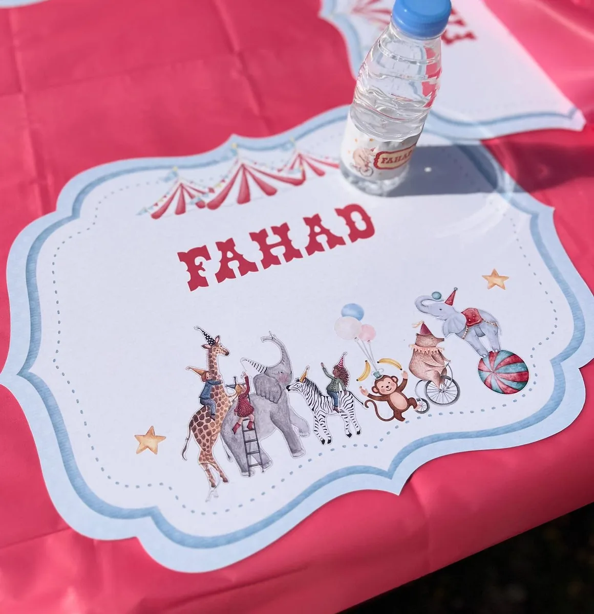 Personalized circus placemat with illustrated animals on a red party table