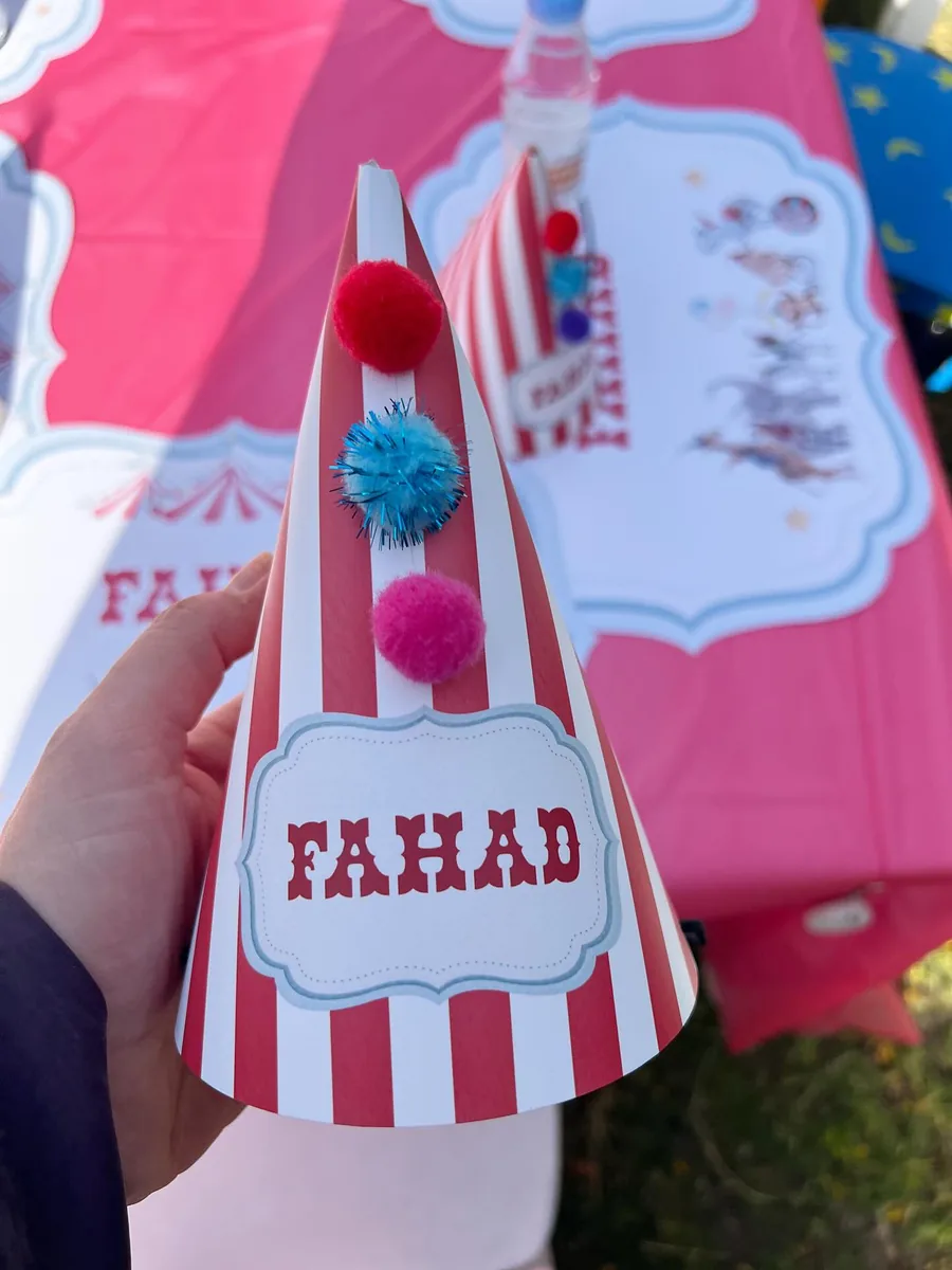 Red and white striped circus party hat personalized with a child’s name