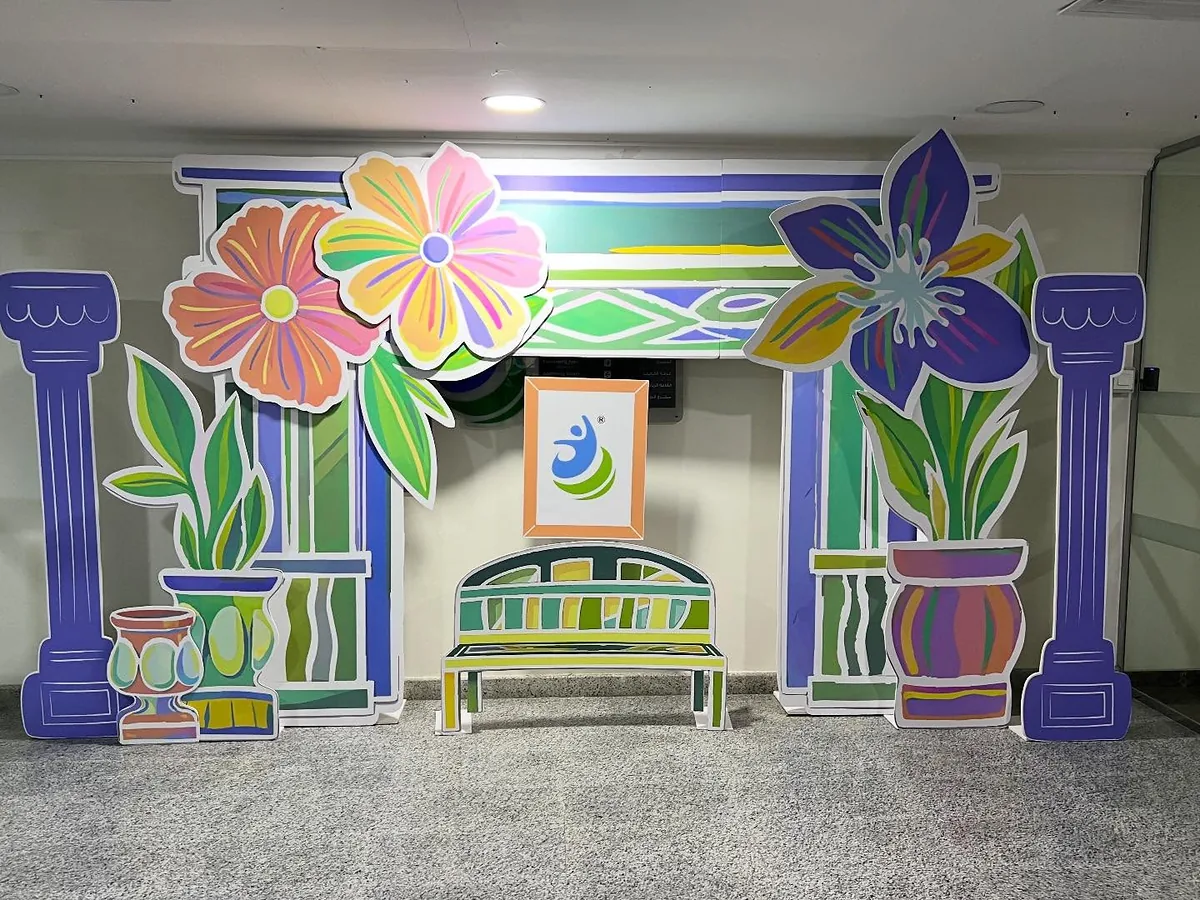 Colorful floral stage installation with oversized flowers and architectural panels
