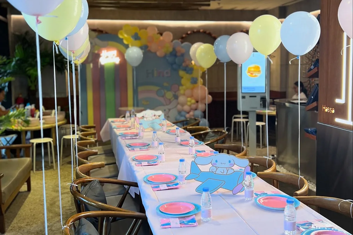 Long pastel birthday table with coordinated plates, balloons and place settings