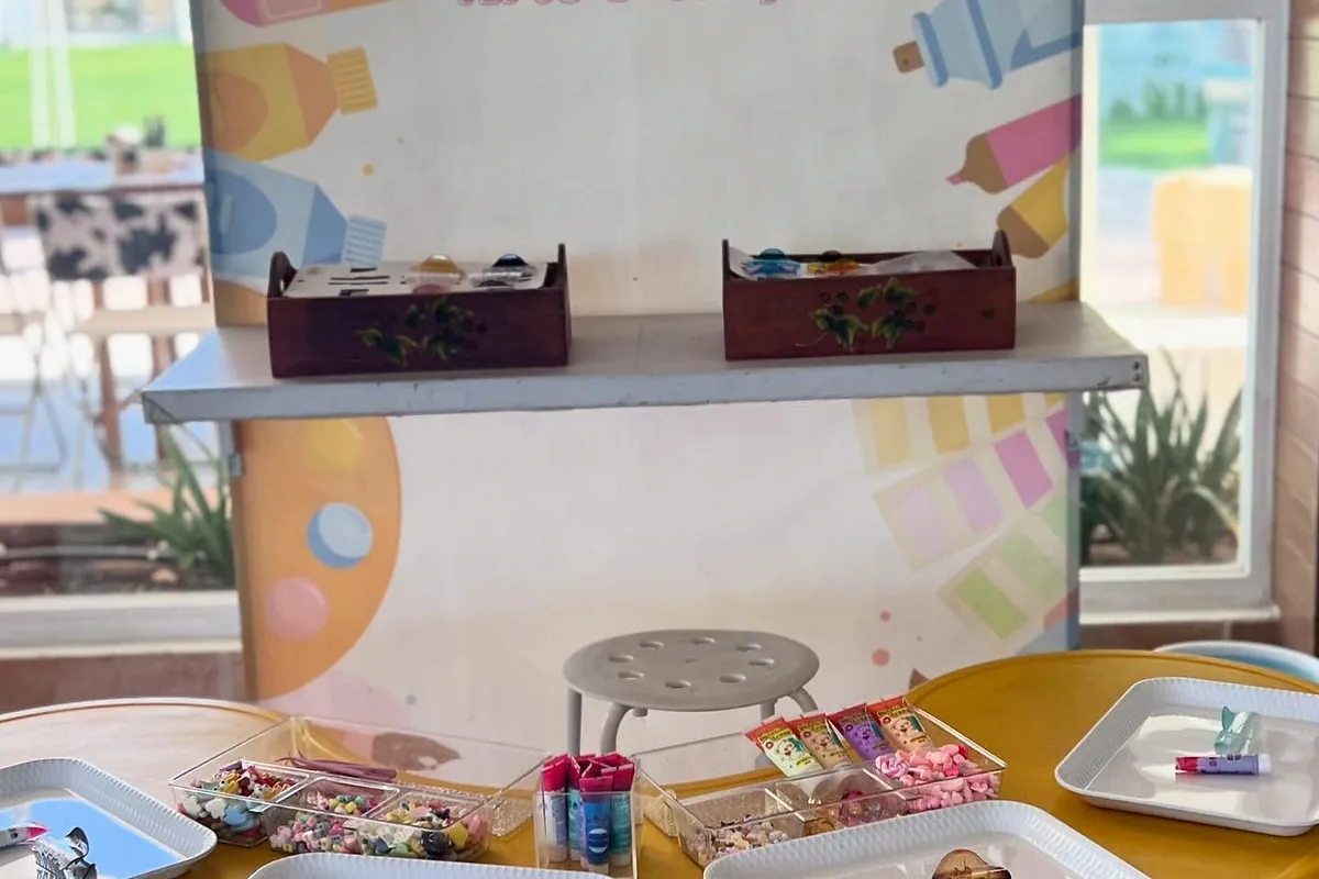 Children’s arts and crafts station with prepared trays, paints and activity signage