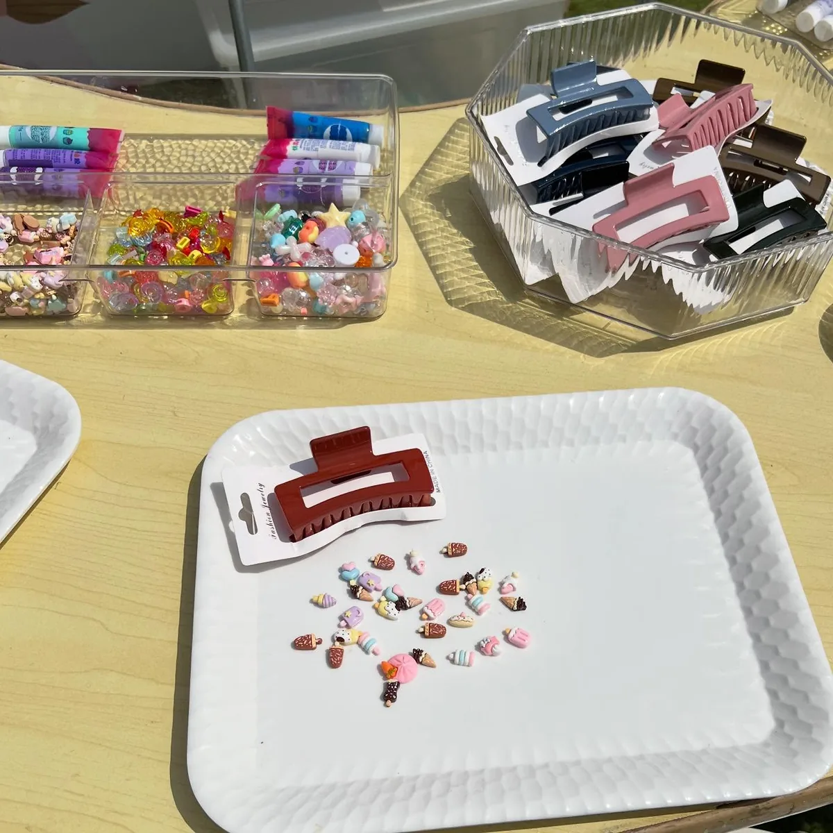 Hair clips, decorative pieces and trays arranged for a children’s craft activity