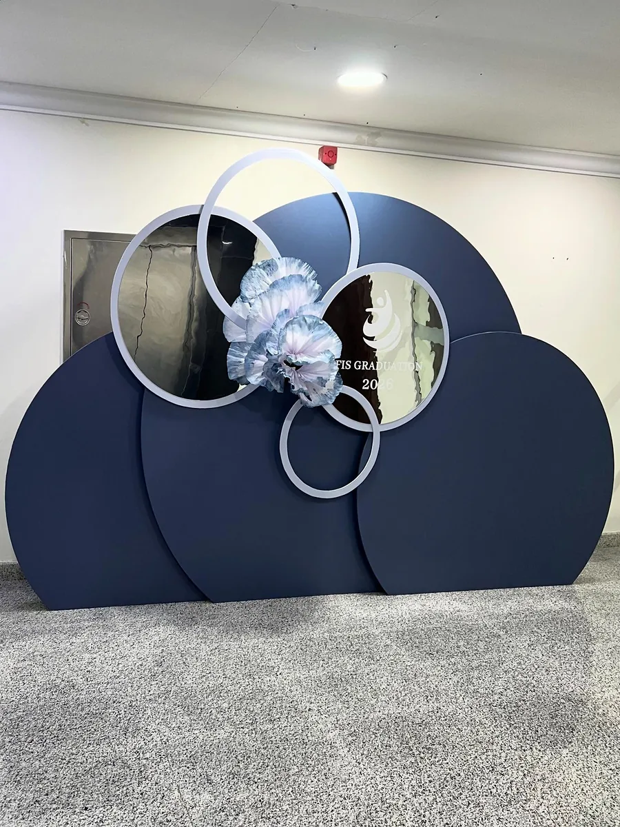 Navy sculptural photo backdrop with white floral accents and circular frames